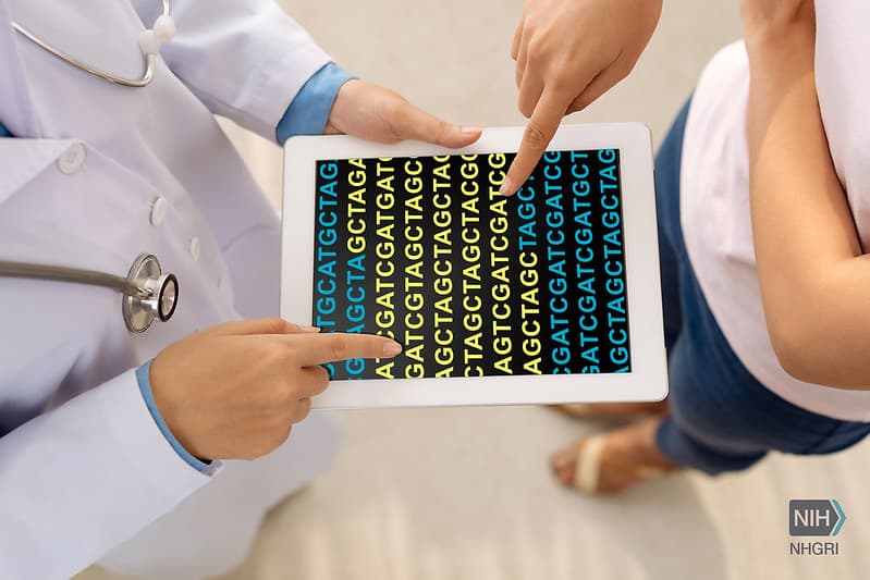 Two people reviewing a genetic report together on a tablet